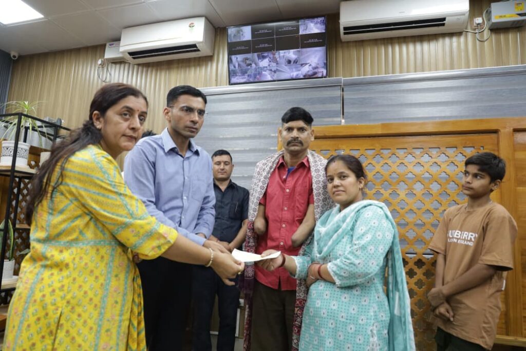 दुर्घटना में दोनों हाथ गंवा चुके मनीष को जिला प्रशासन रायफल क्लब फंड से 50 हजार की आर्थिक सहायता